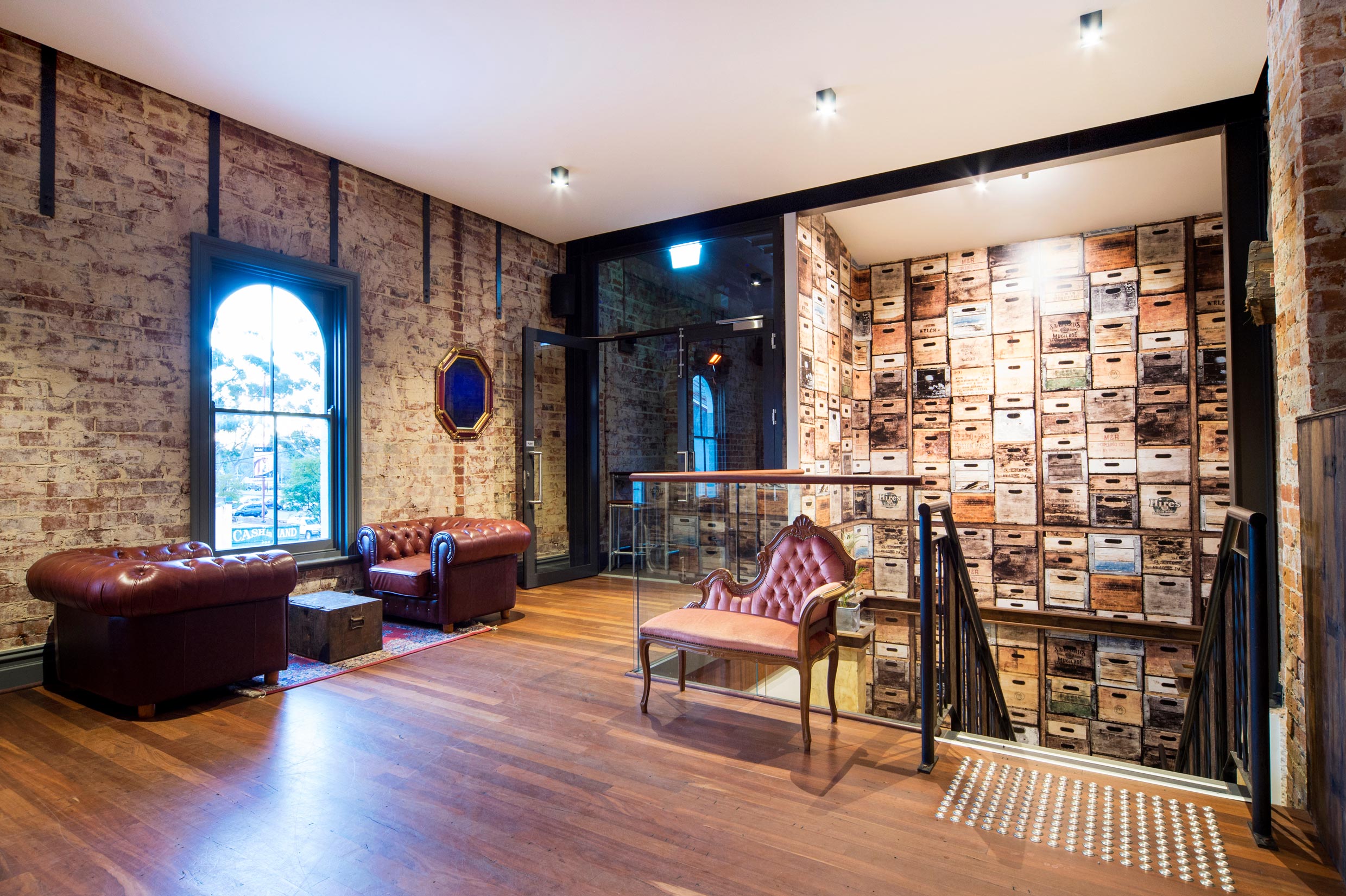 Wallpapered stairwell with leather and velvet lounges on first floor landing of the Guildford Hotel