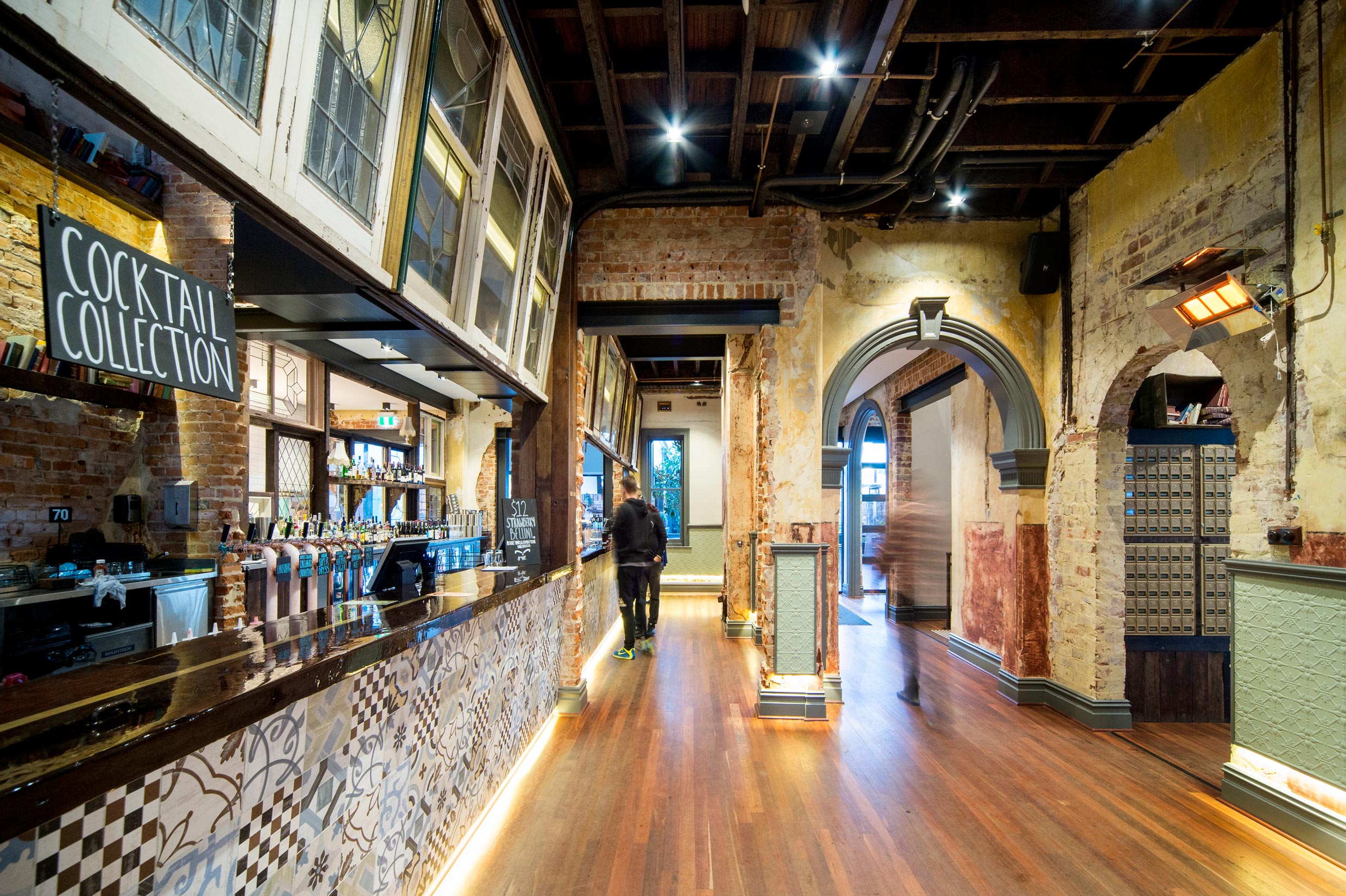 Heritage style bar at the Guildford Hotel with timber floors, tiled bar, exposed brick walls and original archways.