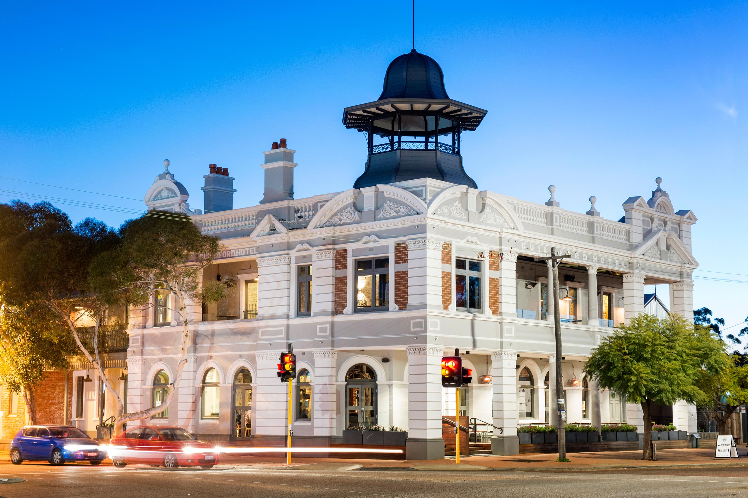 The Guildford Hotel at dusk with light grey and white restored blockwork and a black steel belvedere