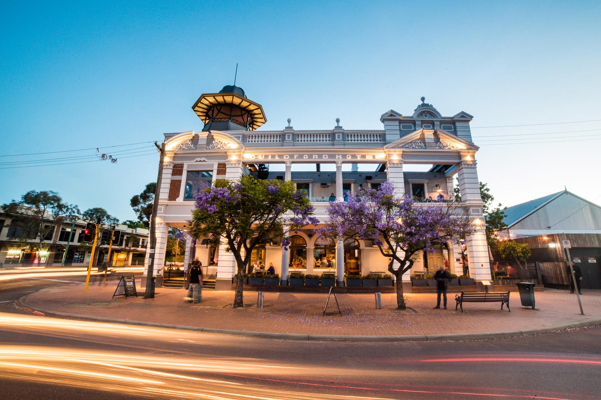 The Guildford Hotel at dusk with light grey and white restored blockwork and a black steel belvedere