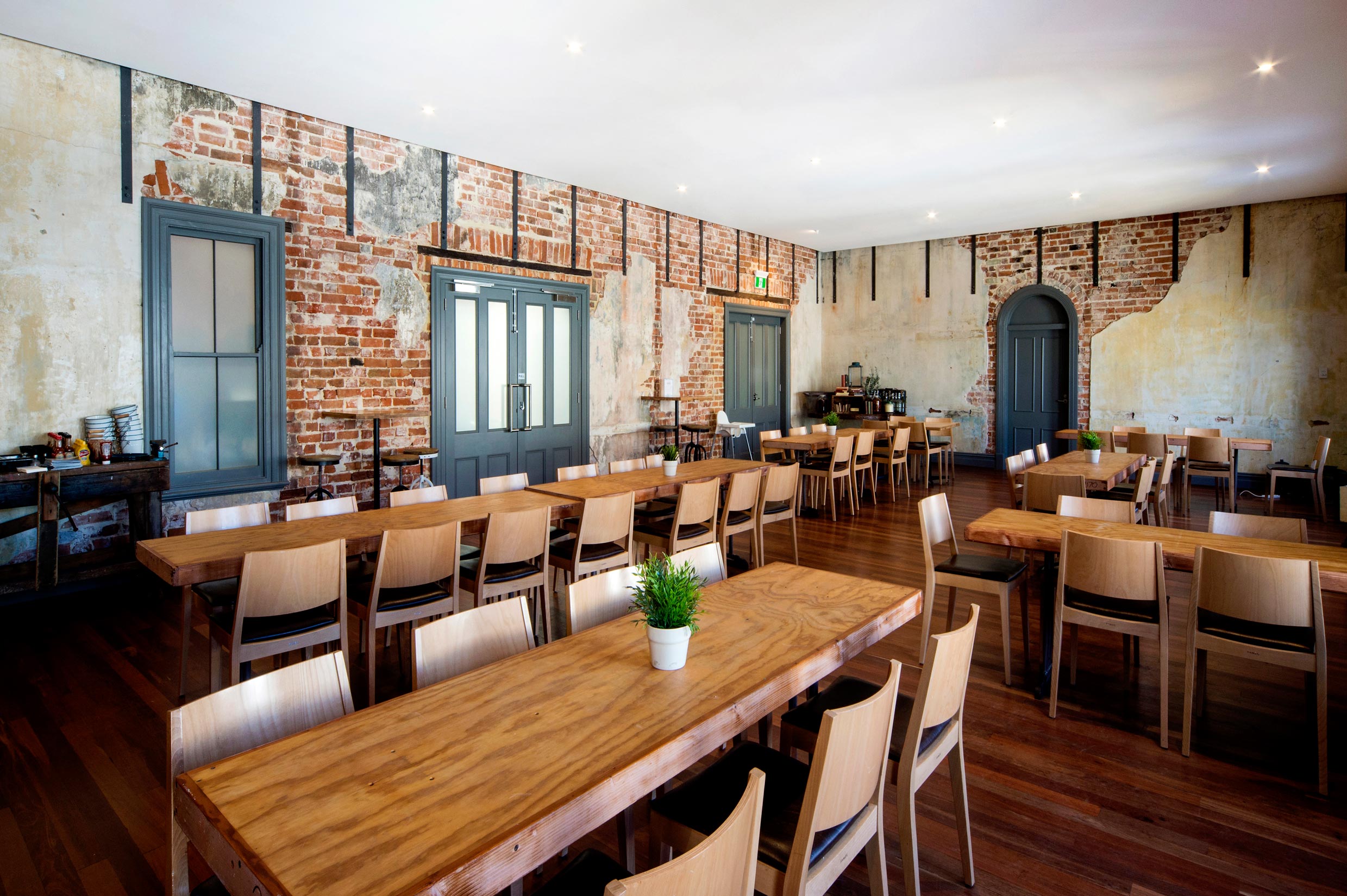 The Guildford Hotel heritage function room with dining tables, and exposed restored brick walls