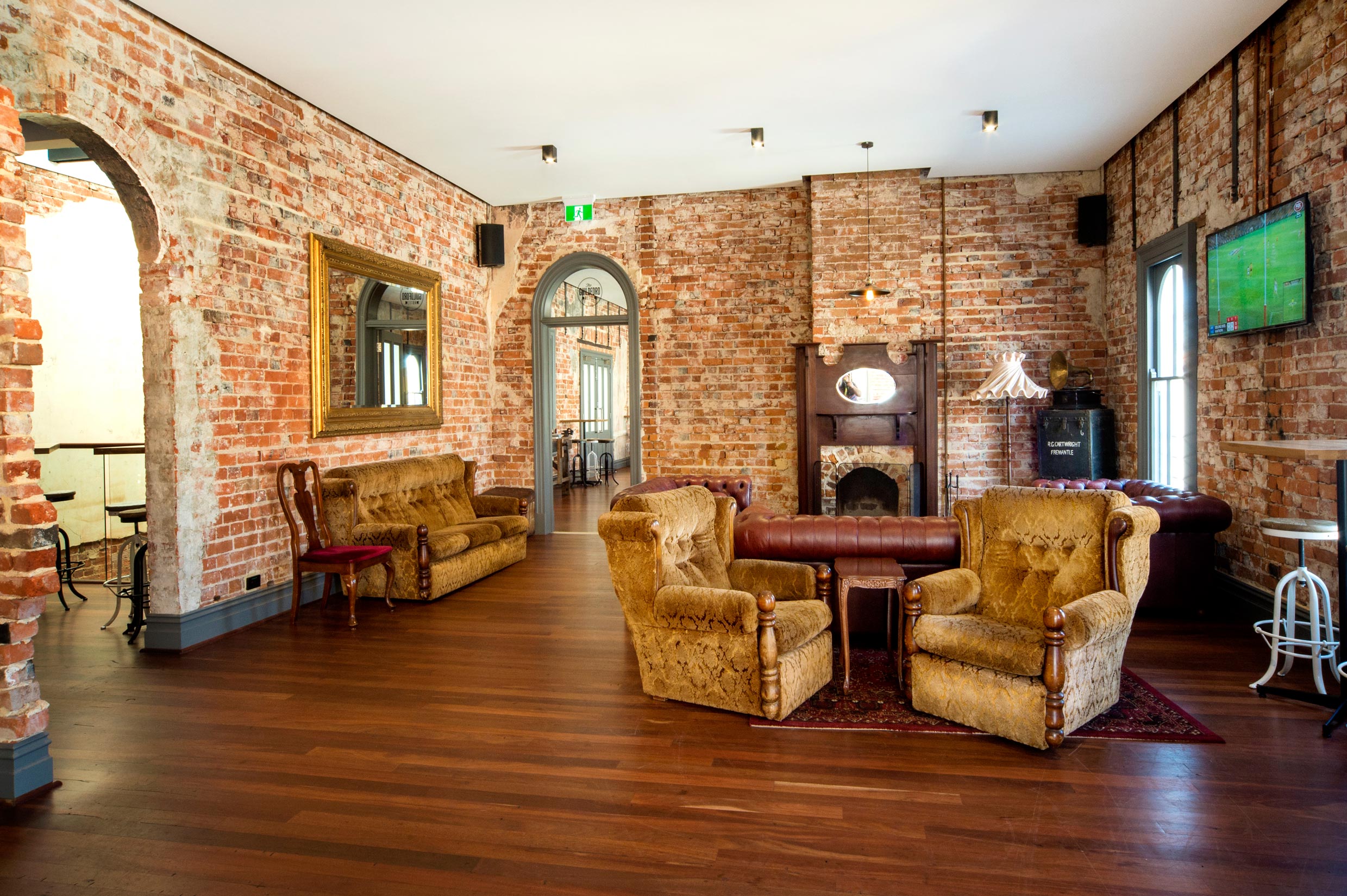 The Guildford Hotel lounge room with exposed brick walls, leather and velvet couches