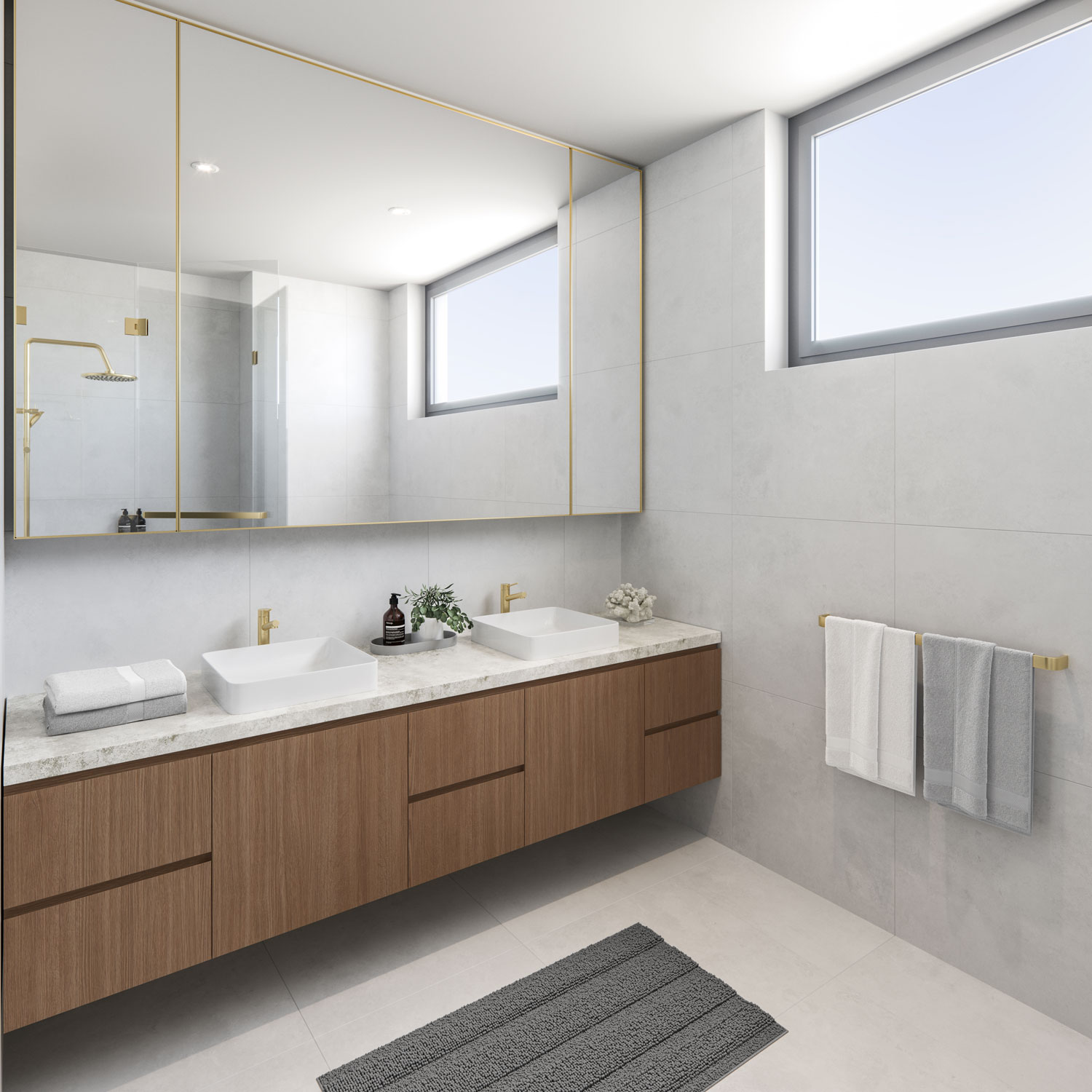 Light grey tiled bathroom, with timber under sink cabinetry, brass tapware fixtures and marble benchtop in Elizabeth Residences Cottesloe Apartments