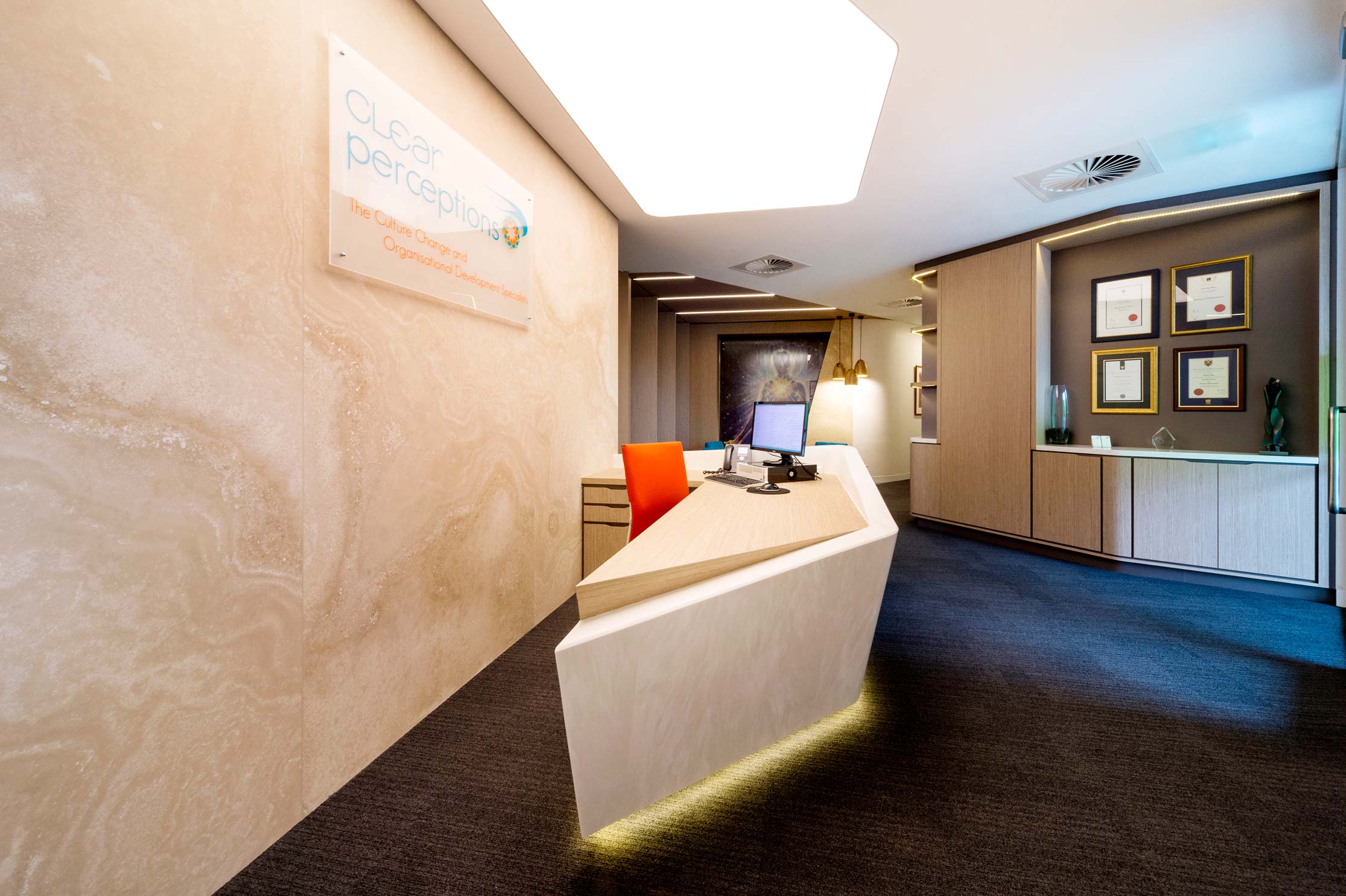 office reception with stone angled reception desk and wall